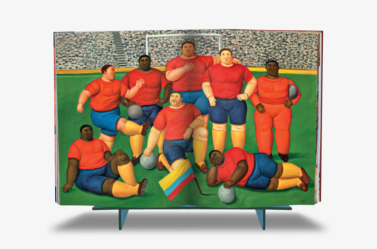 Fernando Botero XXL by Assouline: Full-spread reproduction of Botero's football team — rotund players in red and blue uniforms posed for a team portrait before a packed stadium, the Colombian flag draped in the foreground.