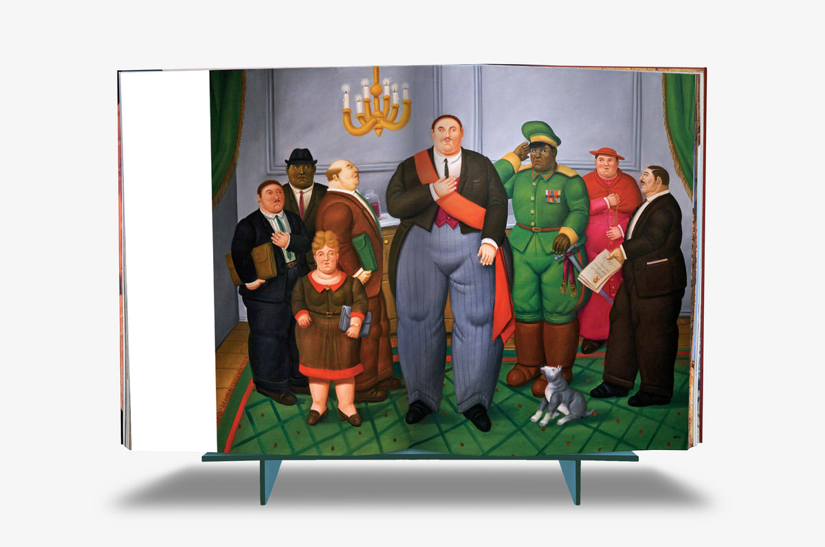 Fernando Botero XXL by Assouline: Book open to Botero's formal group portrait —a gathering of rotund politicians and military men in suits and uniforms beneath a gold chandelier, a small child and cat among them, standing on a green diamond patterned carpet with emerald curtains.
