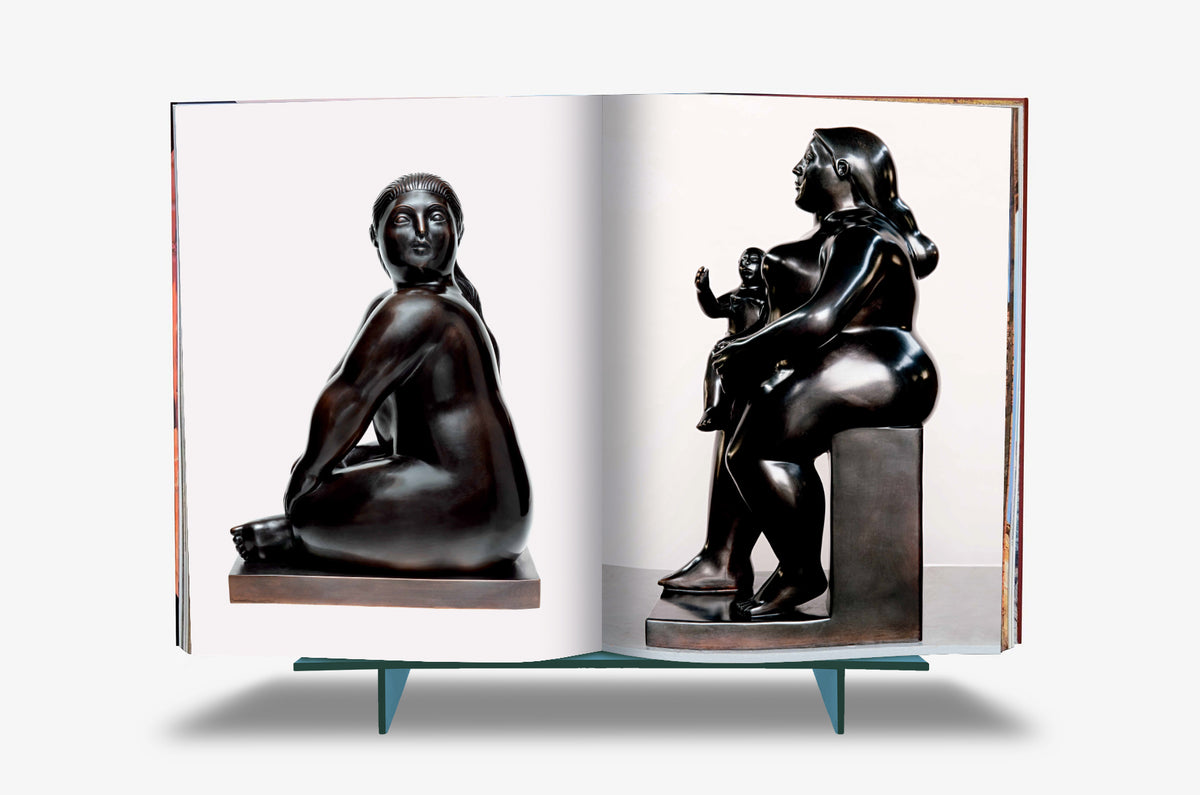 Fernando Botero XXL by Assouline: Book open to a spread of Botero bronzes — a polished dark bronze of a seated female figure on the left page, and a seated mother cradling a small child on the right, both rendered in his signature volumetric forms