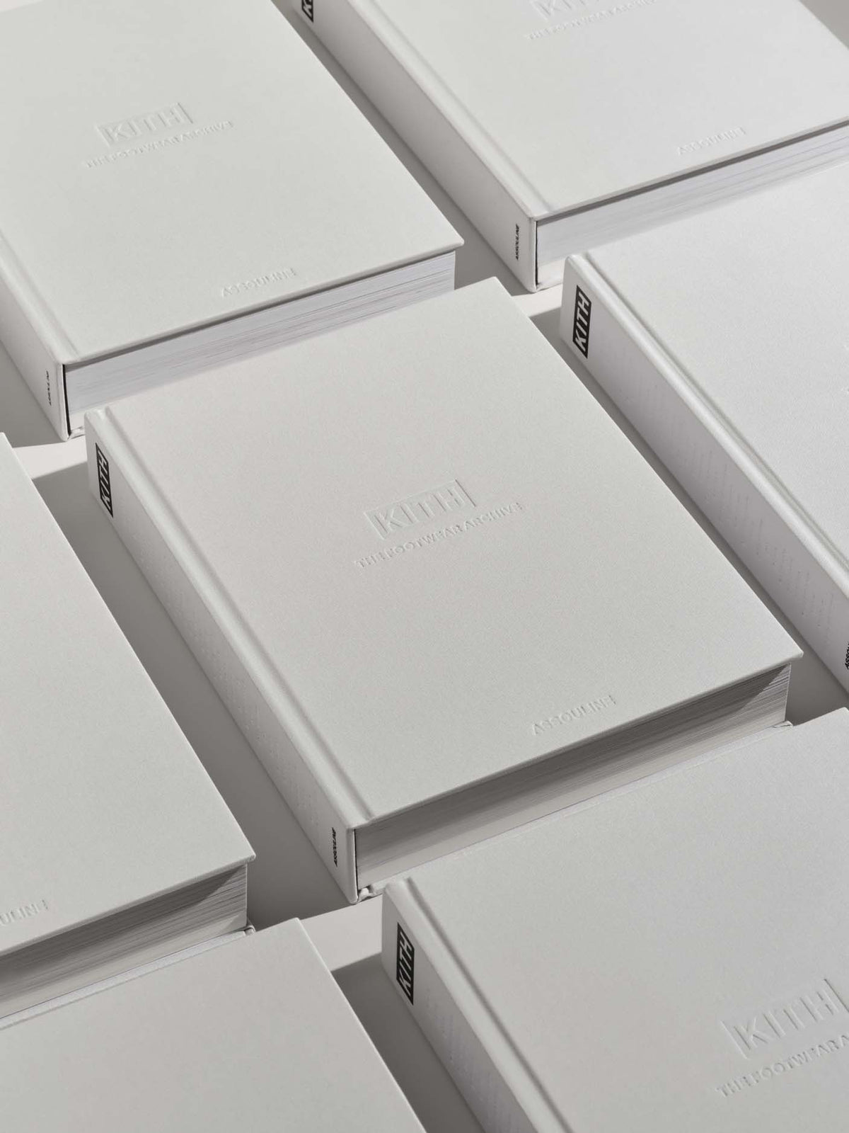 A close-up view of multiple white rectangular boxes arranged in an overlapping grid. The top surfaces have faint embossed text, including the brand name 'KIMJI' and smaller product text, while side tabs show 'KIMJI' and 'BAGS'.