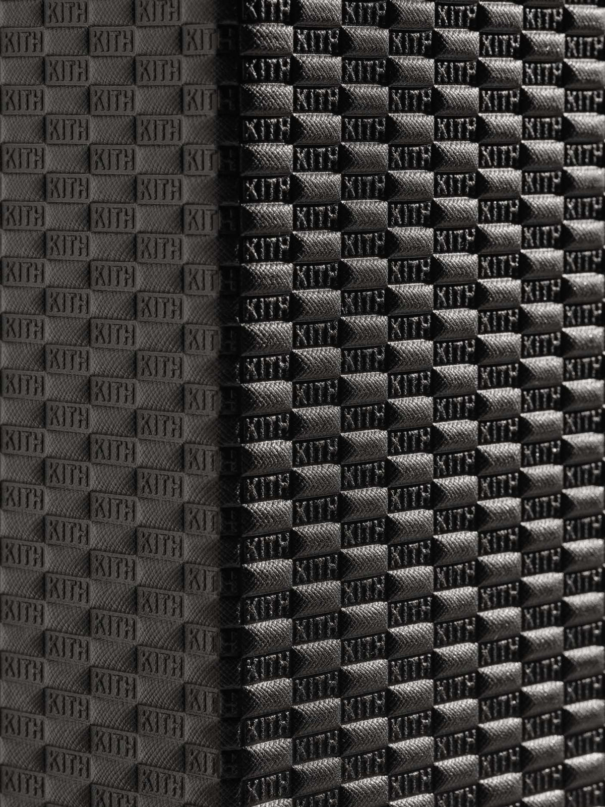 Close-up of a black textured fabric or foam surface with a repeating embossed Kith logo pattern.
